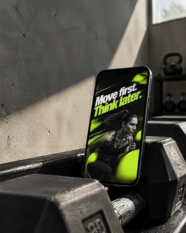 Phone on a gym dumbbell rack playing an animated lime and black story ad for a gym