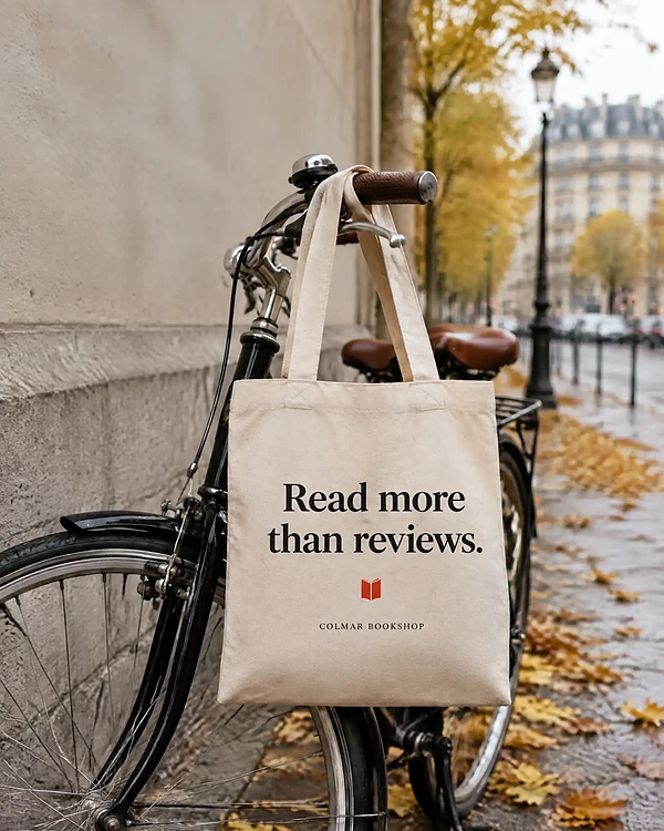 Tote bag on a bicycle in Paris printed with a bookshop tagline in big black letters