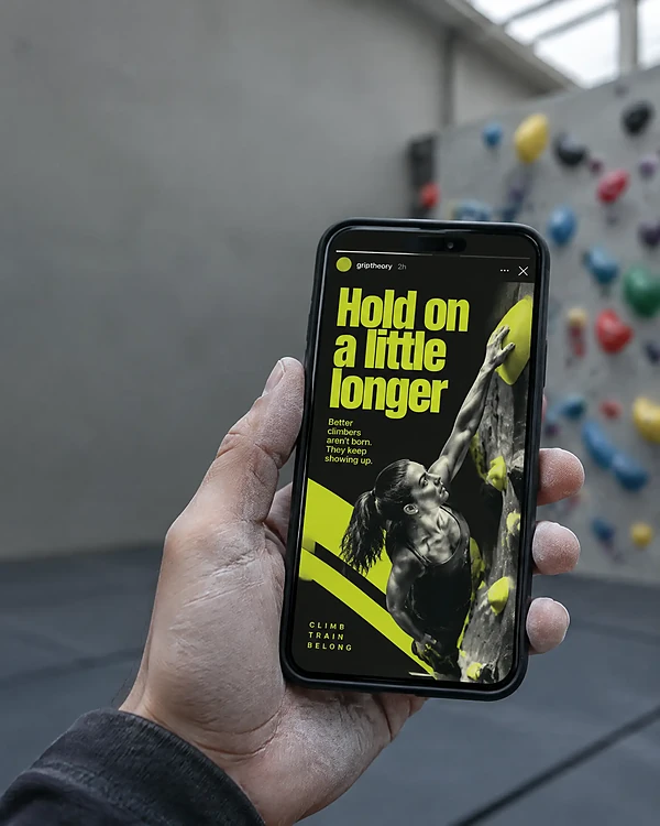 Hand in a climbing gym holding a phone with a bold social story ad