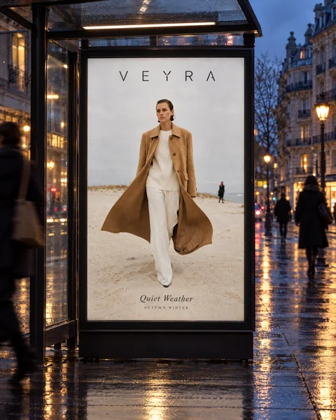 VEYRA Quiet Weather poster in a bus shelter at dusk