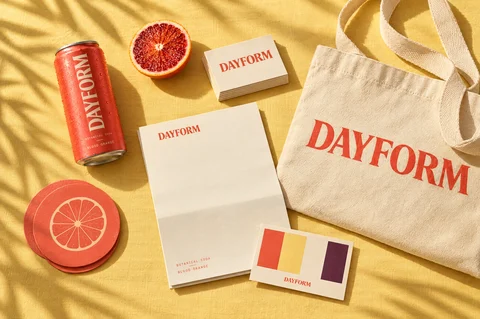 DAYFORM identity on yellow linen: the can, a tote, business cards, letterhead, coasters and colour swatches