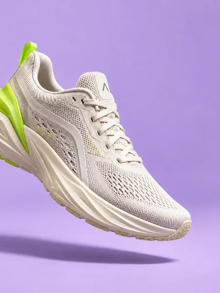 A light grey FORMA running shoe floating over a lilac background